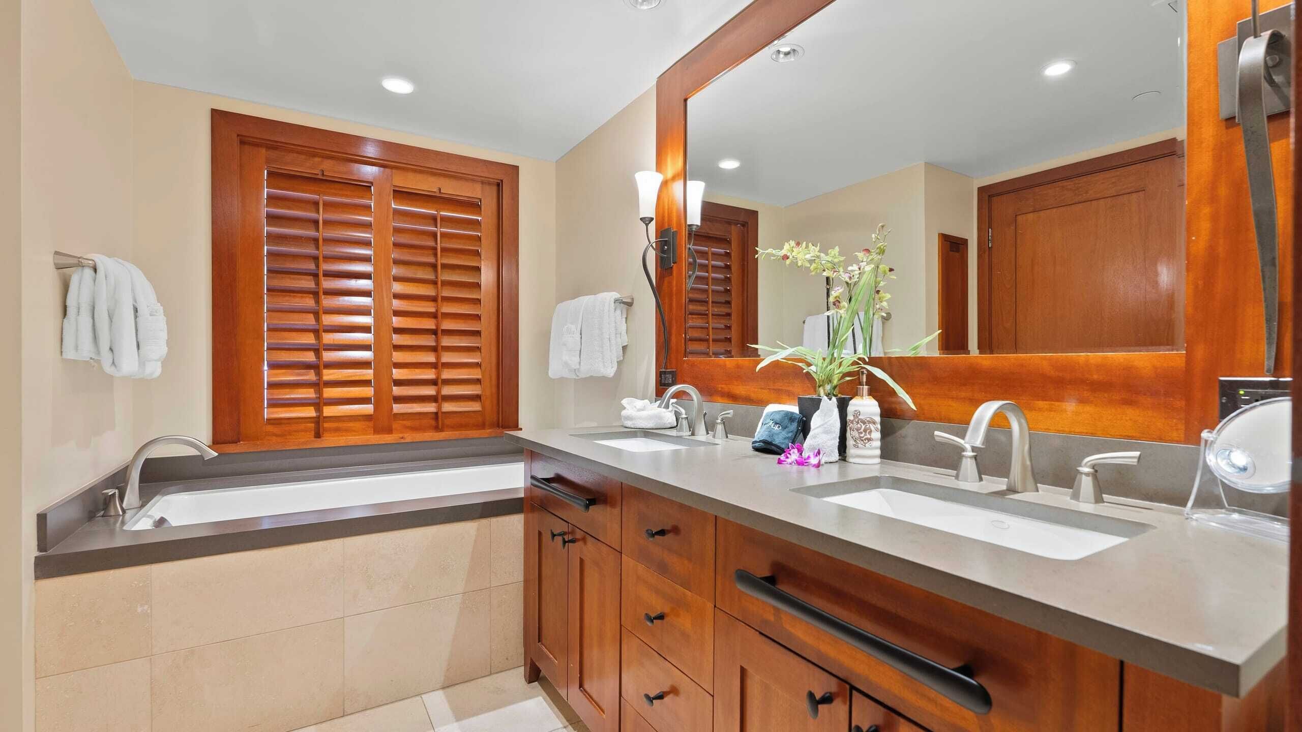 Un bagno moderno con due lavabi, mobili in legno e un grande specchio.