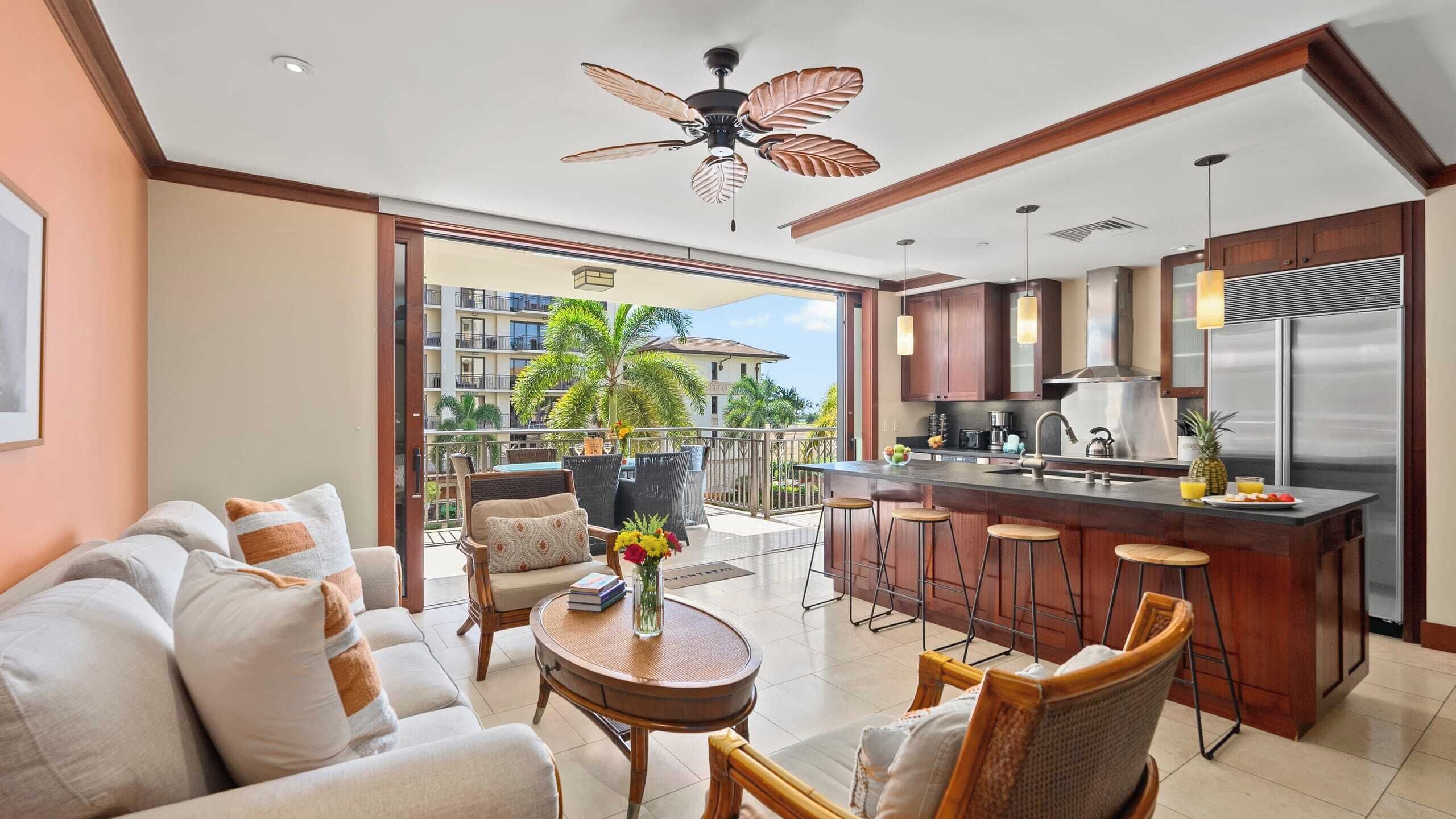 A modern kitchen with a central island, bar stools, and a view of a residential building.