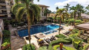 A pool area with lounge chairs and a large pool, surrounded by palm trees and greenery. - Beachfront Condo at Beach Villas at Ko Olina Hale Hoaloha by Avantstay (Kapolei)