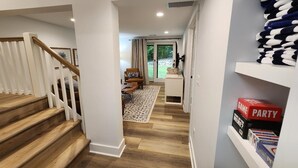 A hallway with a wooden staircase, a rug, and a door leading to a room with a view. - Gorgeous 4 bedroom condo - 10 minutes from Harbor Springs & Ski Resorts (Harbor Springs)
