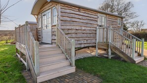 Eine Blockhütte mit Veranda, einer Treppe und einem kleinen Außenbereich.