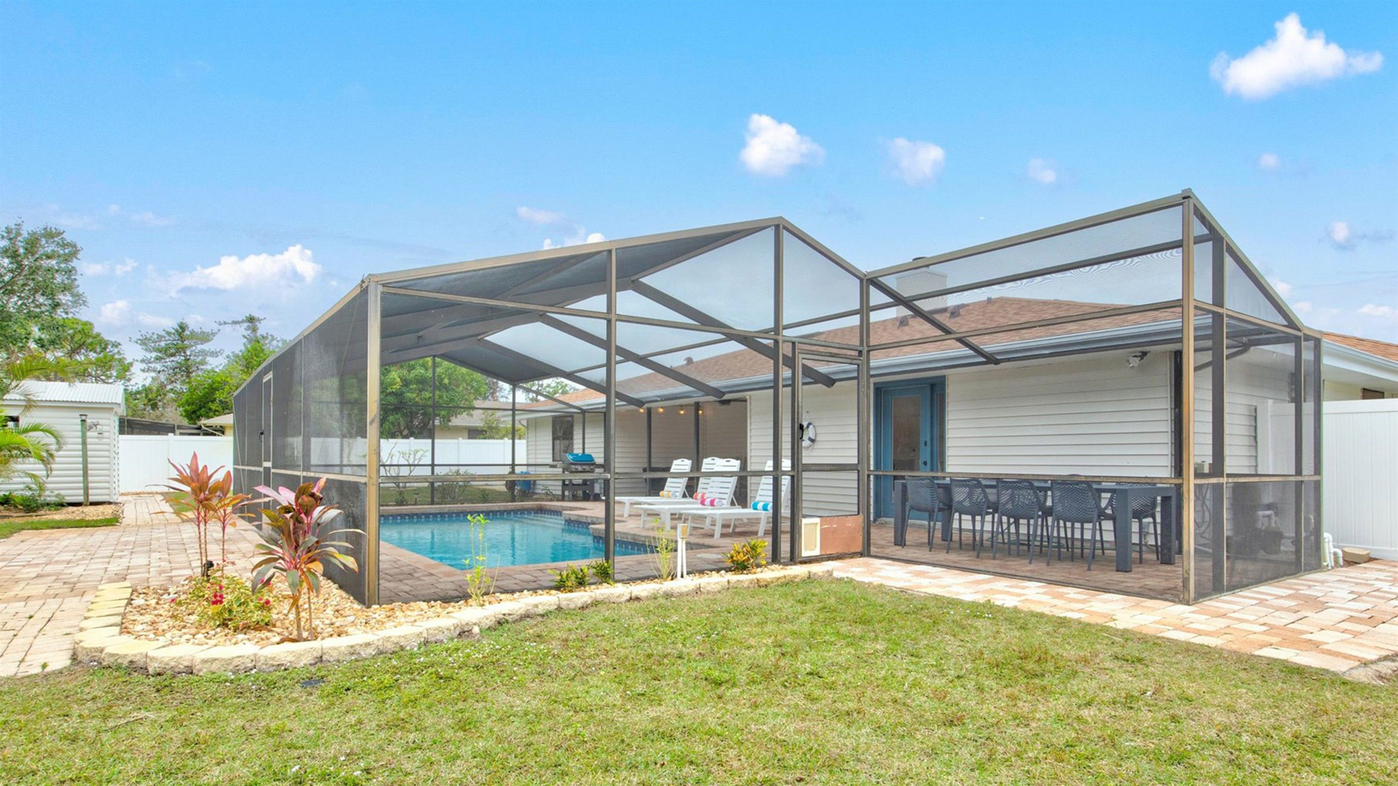A covered patio area with a pool, outdoor seating, and a view of the backyard.