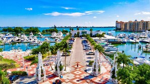 Stroll along the marina's promenade, lined with palm trees and a geometric walkway, offering scenic views of the docked boats.
