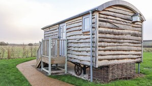 A log cabin with a porch and a small staircase leading up to the entrance.