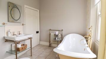 A bathroom with a white sink, a toilet, a bathtub, and a radiator.