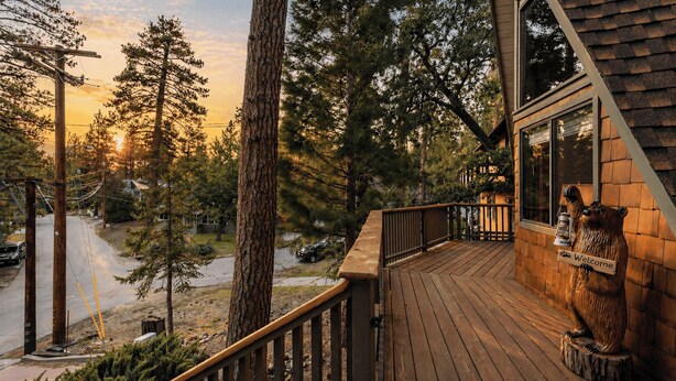 Une terrasse en bois offrant une vue sur une forêt et une route.