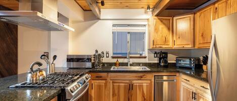 A modern kitchen with wooden cabinets, a stainless steel stove, and a dishwasher.