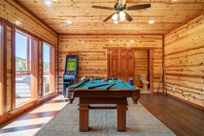 Relax in this inviting room with a pool table, television, and window offering a view of the outdoors.