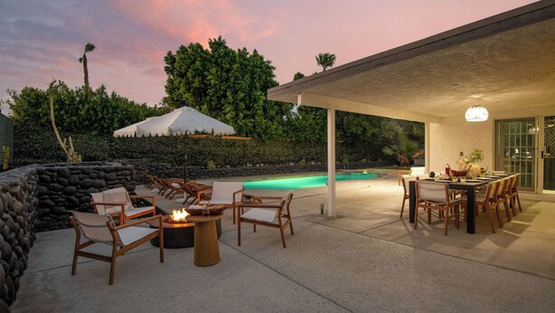 A covered outdoor area with a pool, lounge chairs, a fire pit, and a dining table. - Yellowjacket by Avantstay Entertainers Yard 10min to Downtown (Palm Springs)