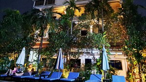 A hotel with a pool area, lounge chairs, and umbrellas. - Nary Villa (Siem Reap)