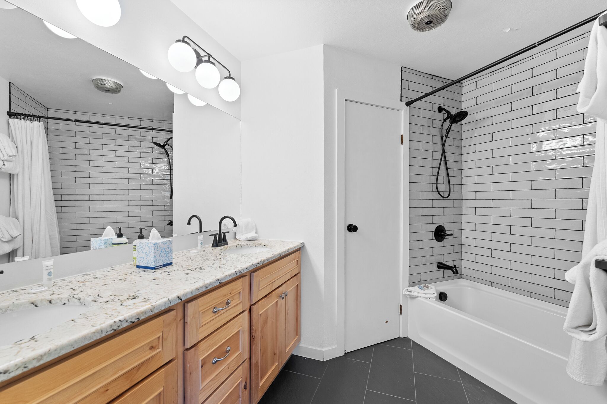 A modern bathroom with a shower, a vanity with a mirror, and a bathtub.