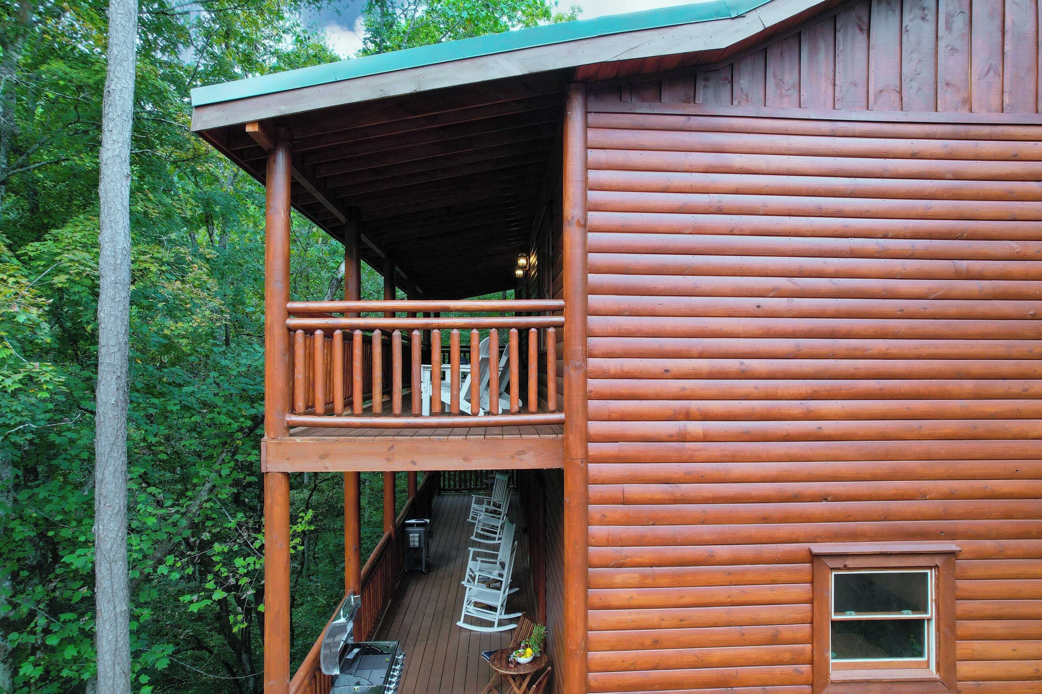 A wooden cabin with a balcony, a deck, and a small window.