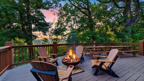 Une terrasse avec un foyer, des chaises et des tables en bois.