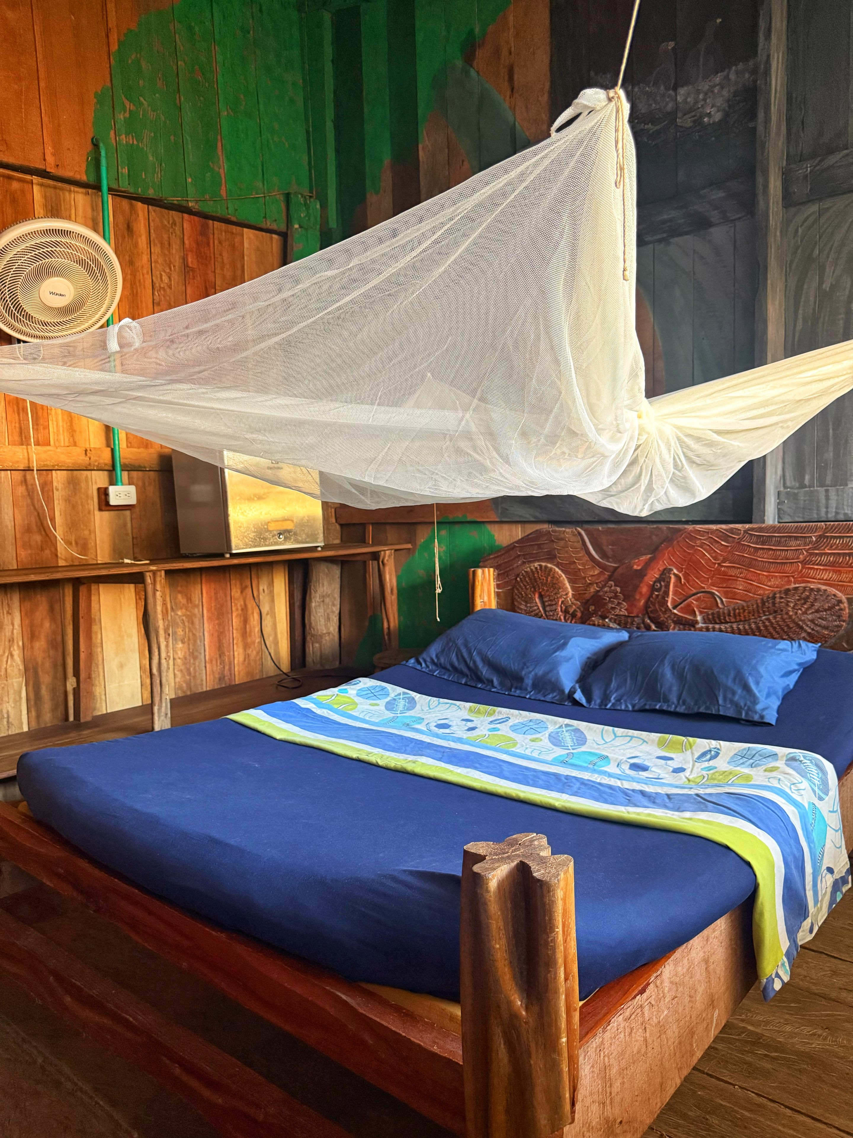 A bed with a blue mattress and a canopy.