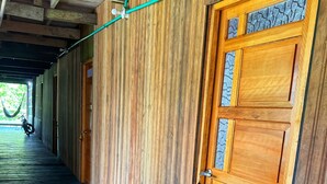 A hallway with wooden walls and a blue floor, leading to a wooden door with a keyhole. - Authentic Amazon | Indigenous Lodging and Jungle Tours (Loreto Mocagua)