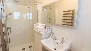 A modern bathroom with a glass-enclosed shower, a white sink, and a mirror above the sink. - Arts and Crafts (York)