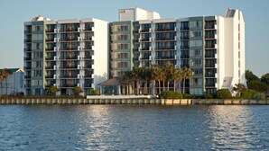 A multi-story hotel with balconies, a pool area, and palm trees. - Bayside Sandestin studio @ Links golf & conference center (Miramar Beach)