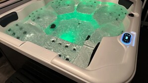 Uma banheira de hidromassagem com painel de controle digital e um detalhe aquático transparente.