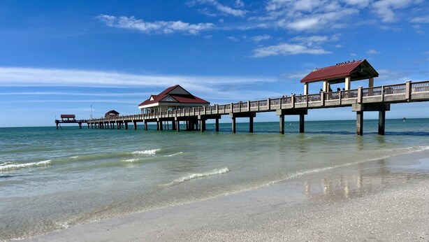 A pier extending into the sea with a covered walkway and buildings at the end. - Clearwater Beach, Your Dream Vacation, Condo (Clearwater)