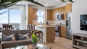 Eine moderne Küche mit Holzausstattung, Edelstahlgeräten und einer zentralen Kochinsel.