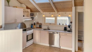 A kitchen with a skylight, wooden ceiling, white cabinets, a stove, a dishwasher, and pendant lights. - 3 bedroom awesome home in Hejls (Hejls)