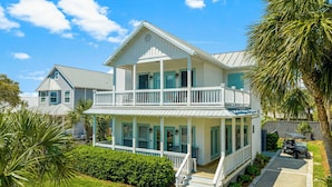 A two-story house with a balcony, a covered porch, and a driveway. - Private Heated Pool - 3 Min Walk to Beach - Golf Cart - Beach Chair Service (Destin)