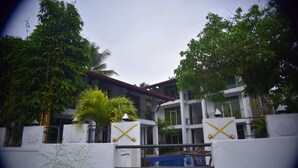 A multi-story building with a white exterior, balconies, and a gated entrance. - Shiromi Hotel Katunayaka (Seeduwa - Katunayake)