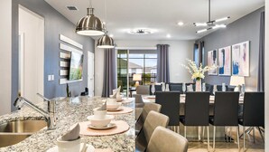 Eine moderne Küche mit Granit Arbeitsplatten, Edelstahlgeräten und Pendelleuchten.