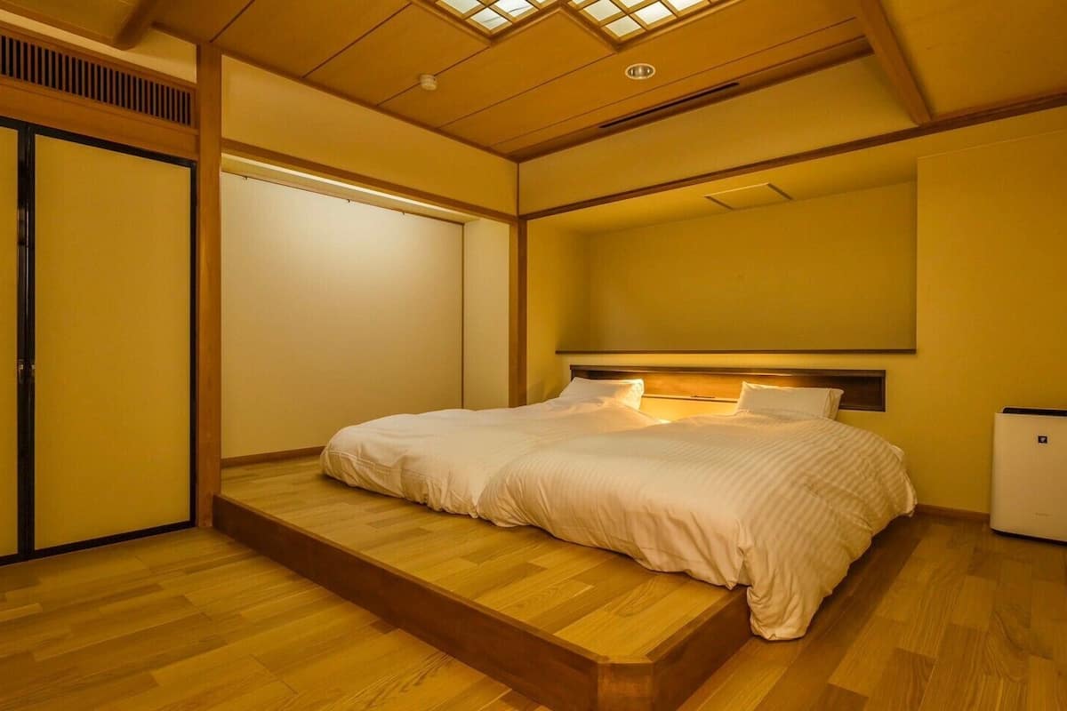 A room with a bed, a small heater, and a sliding door.
