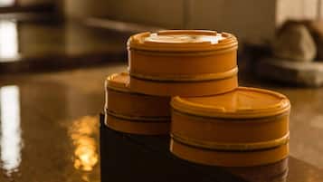 Three stacked containers with lids on a reflective surface.