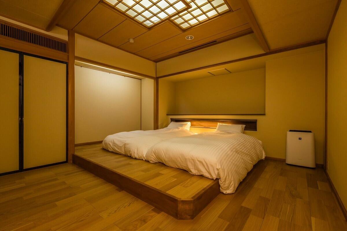 A bedroom with a bed, a heater, and a sliding door.