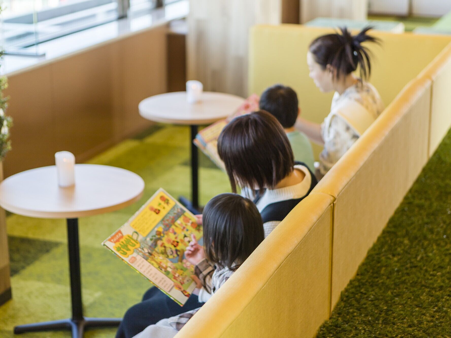 A seating area with yellow partitions and small round tables.
