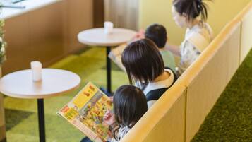 A seating area with yellow partitions and small round tables.