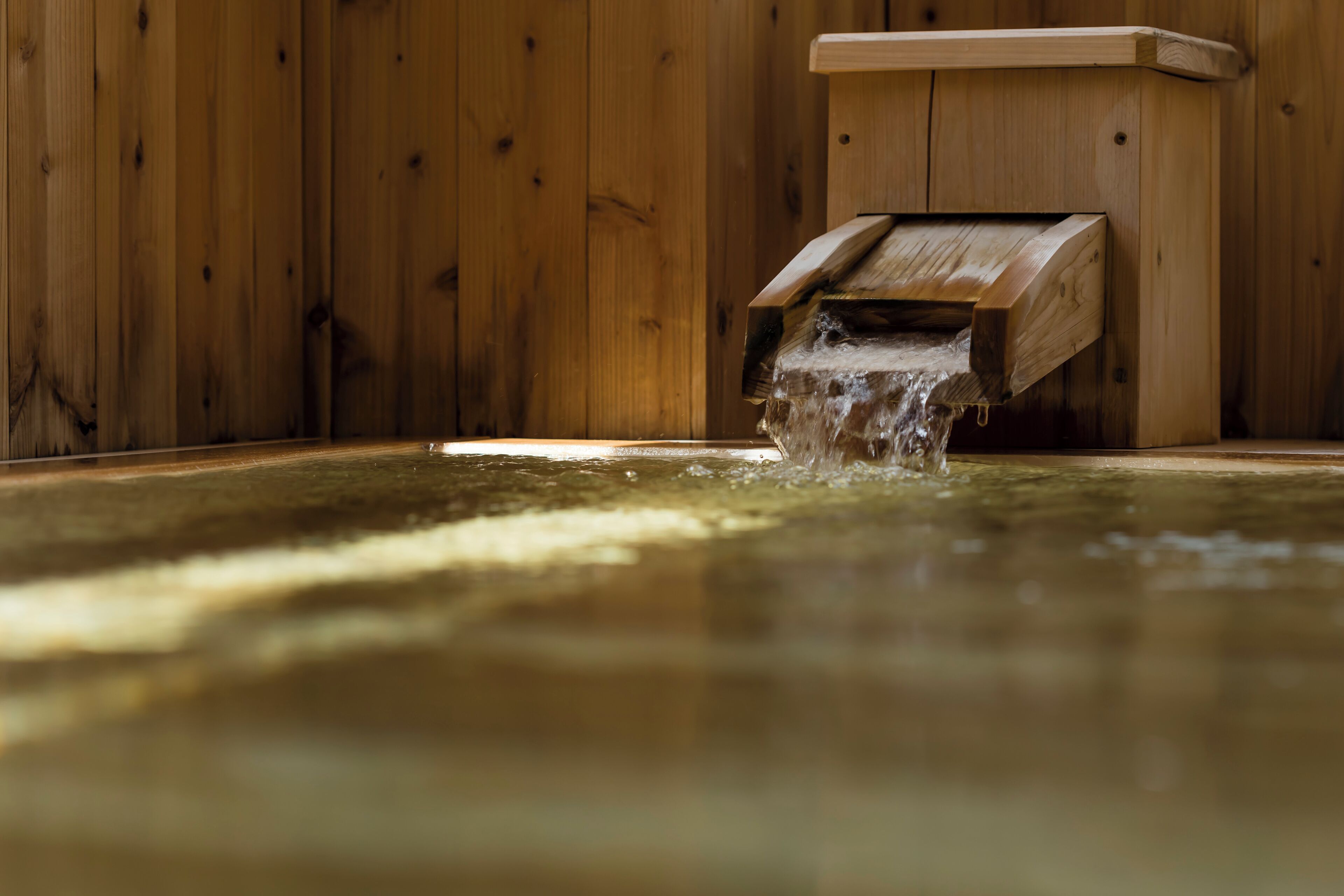Un sauna en bois avec un banc en bois et un élément décoratif aquatique.