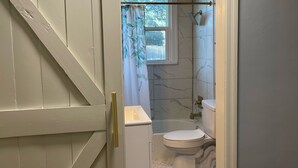 A bathroom with a toilet, sink, and shower. - Hidden Oasis of West Columbia (West Columbia)