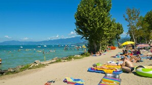 Ein Strand mit Menschen, die sich sonnen, schwimmen und Luftmatratzen benutzen.