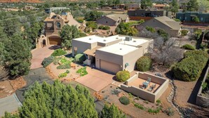 A residential area with houses, a patio with outdoor furniture, and a mountainous backdrop. - Stylish and comfortable home in a prime location. Close to golf, hiking & biking (Sedona)