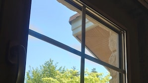Una ventana con vistas a árboles y un edificio.