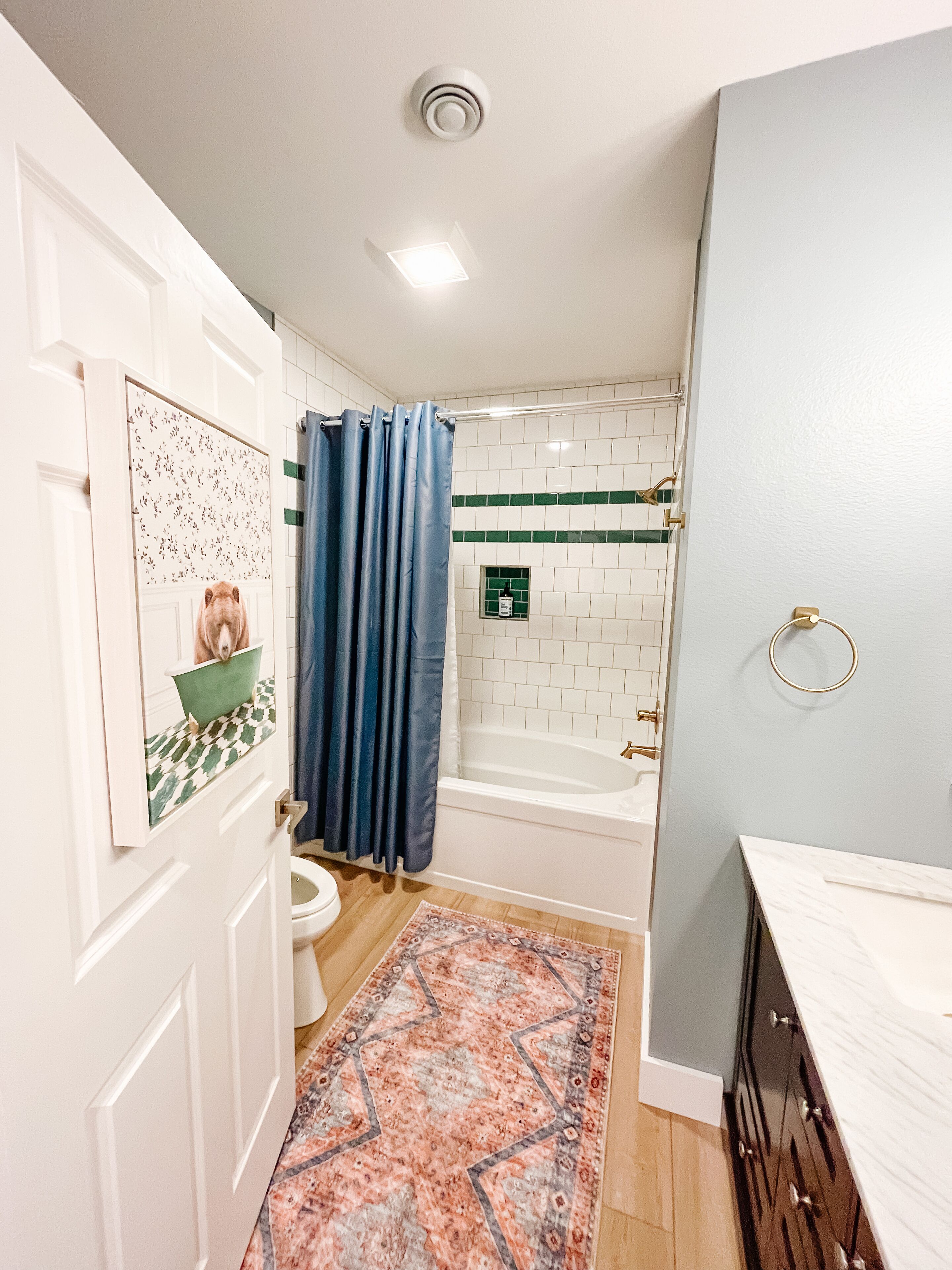 A bathroom with a shower, toilet, and sink.