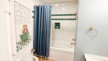 A bathroom with a shower, toilet, and sink.