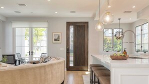 A modern kitchen with a large island, pendant lights, and a view of the outdoors. - Sea Crown by Avantstay 5mins From the Beach w/ Multiple Terraces! Permit#slp13639 (Newport Beach)