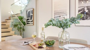A dining table with a glass of white wine, a bottle of wine, a bowl of salad, and a plate of cheese and meats. - Sea Crown by Avantstay 5mins From the Beach w/ Multiple Terraces! Permit#slp13639 (Newport Beach)