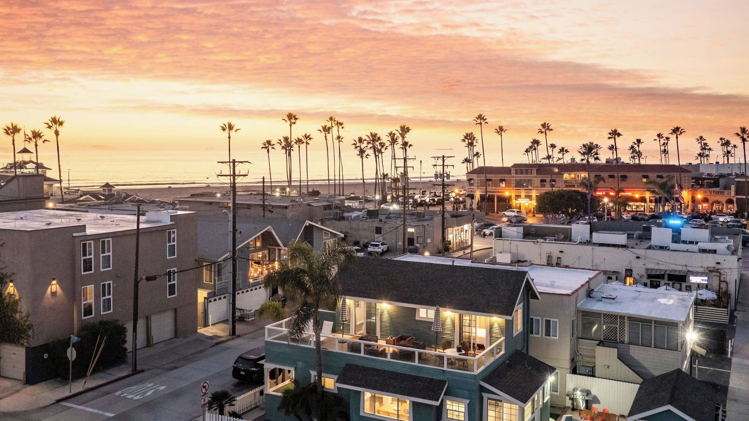 A coastal urban area with buildings, a beach, and palm trees.