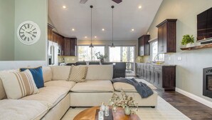 A spacious living room with a sectional sofa, a coffee table, and a fireplace.