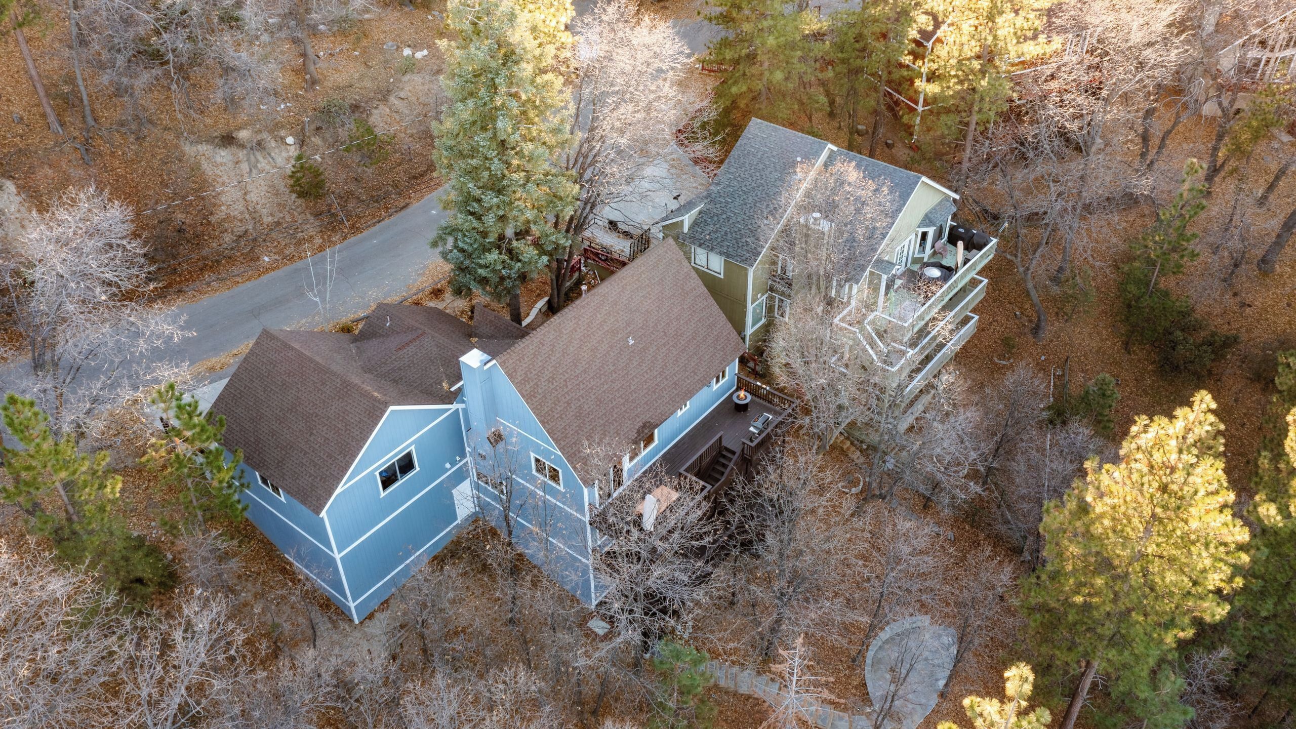 A two-story house with a large deck and a separate garage.