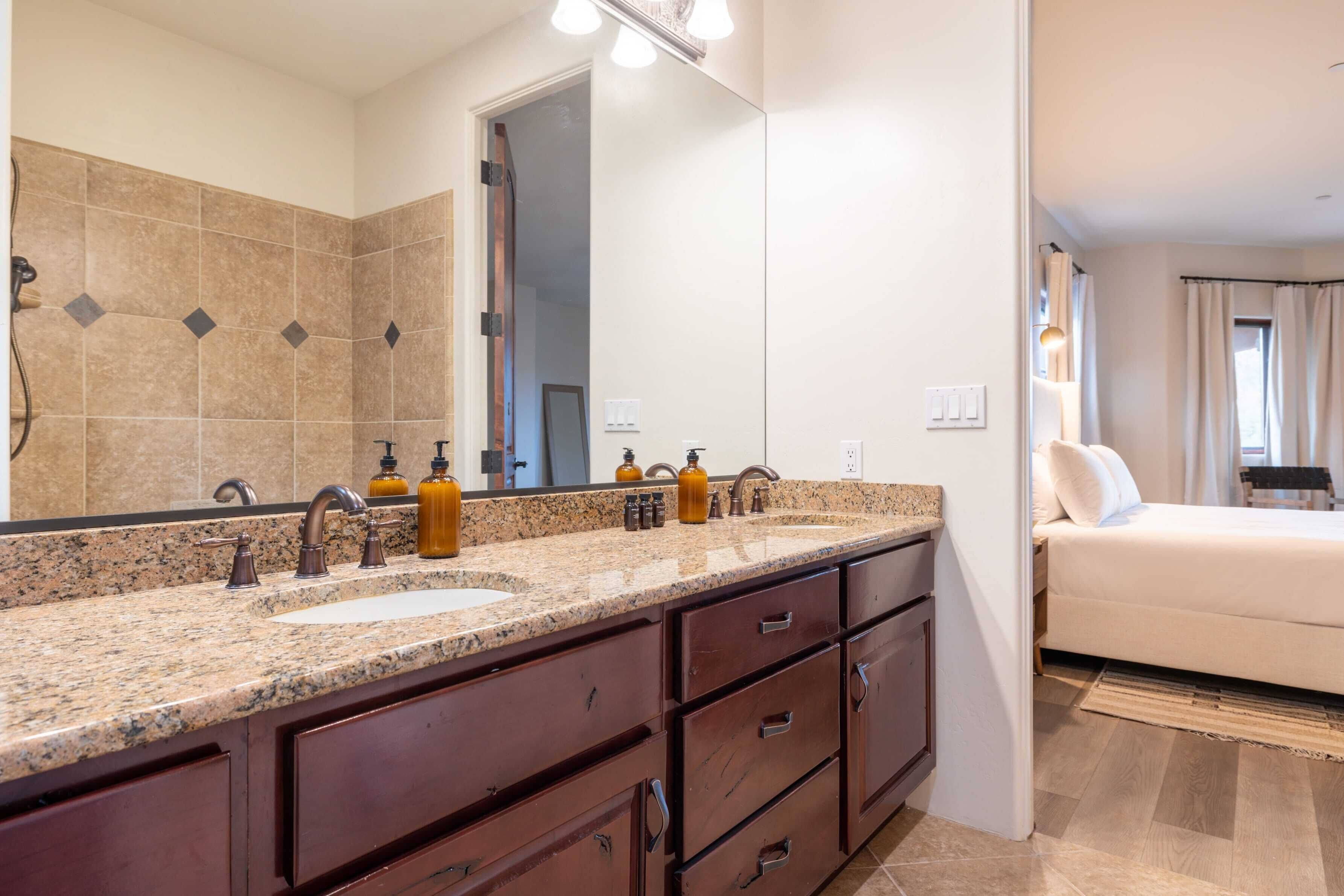 A bathroom with a double sink, dark wooden cabinets, and a large mirror.