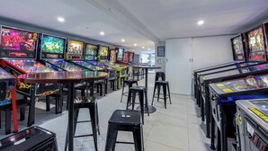 Een rij spelautomaten in een helder verlichte ruimte met betegelde vloeren.