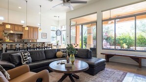 A modern living room with a sofa, coffee table, and a view of the outdoors.