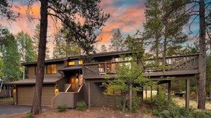 A two-story wooden cabin with a covered porch and a staircase leading to the upper level. - Tanner by Avantstay Modern Cascades Escape (Bend)