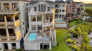 Un edificio residencial de varios pisos con piscina, zona de estar al aire libre y jardín bien cuidado.